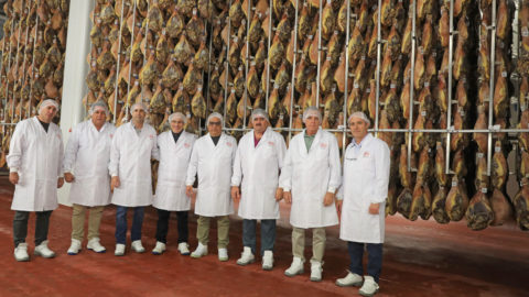 La comitiva junto a los directores generales de Cárnicas Serrano en el secadero de jamones de la compañía
